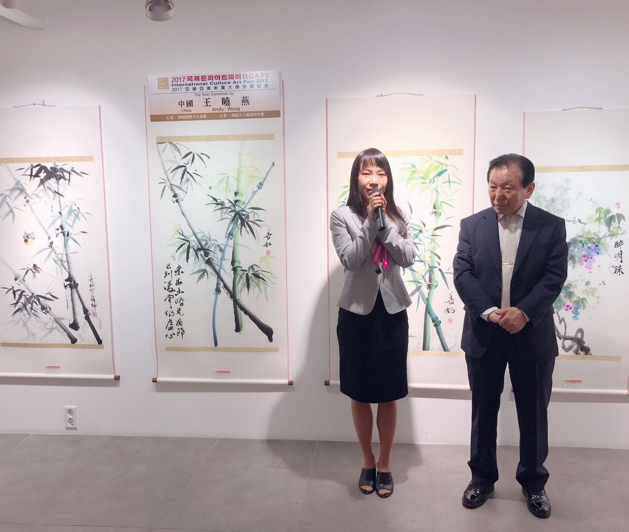 王晓燕在介绍参展作品 ANDY Wong is introducing her paintings to the show by people who have been visiting